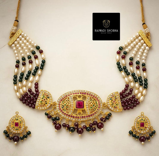 Jadau necklace featuring pearls and green stones, showcasing intricate craftsmanship and elegant design.